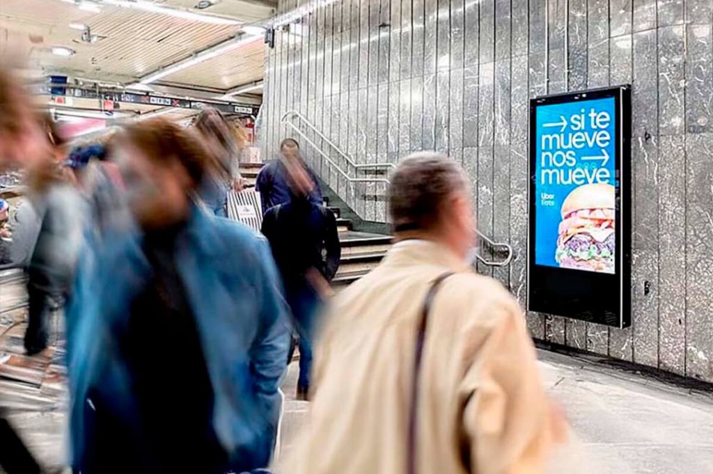 Viajeros en el Metro de Barcelona frente a soportes publicitarios en andén